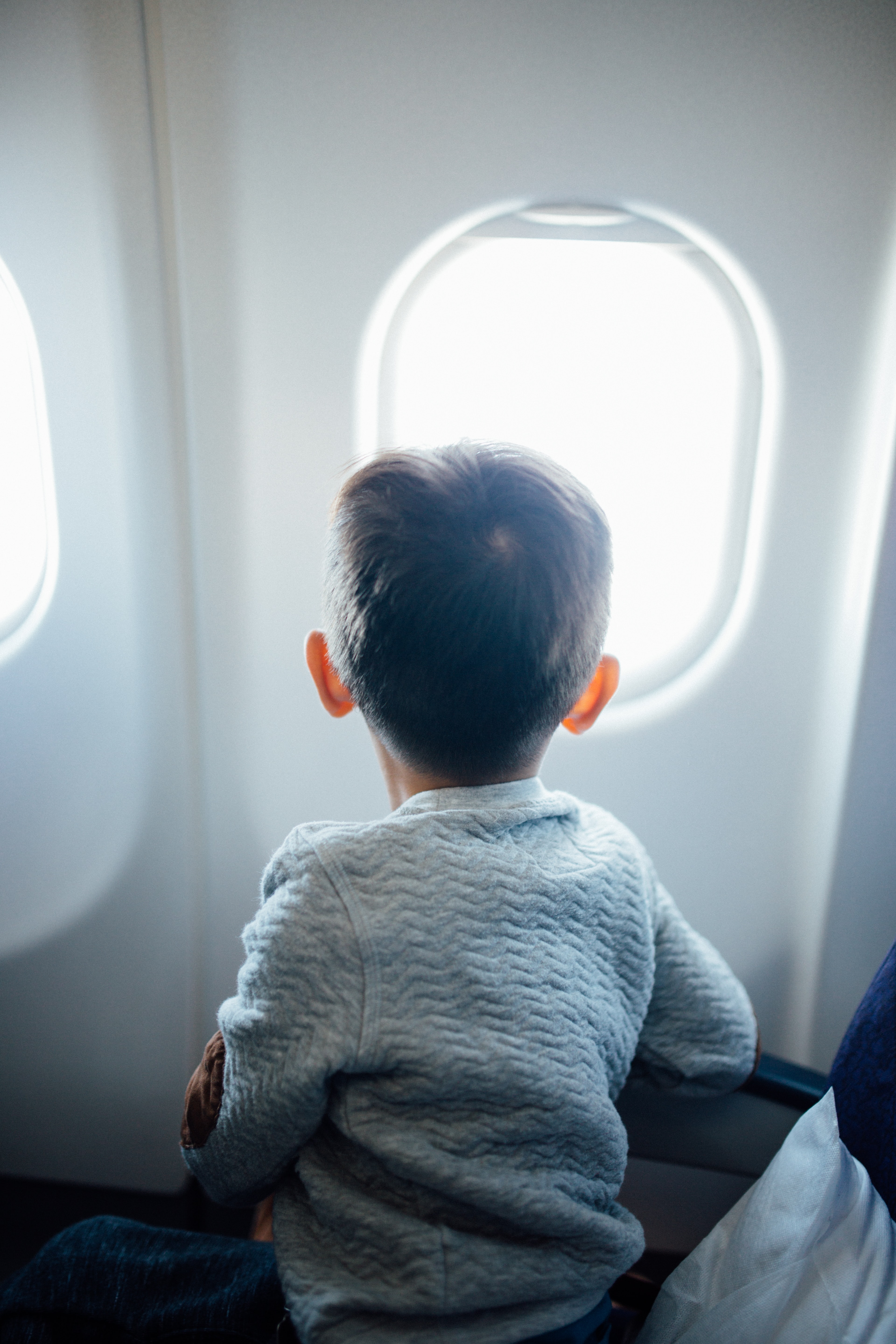Dječak gleda kroz prozor aviona