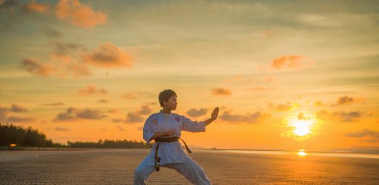 Dječak radi karate tijekom zalaska sunca